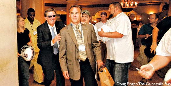 Steve Spurrier, head football coach at South Carolina, avoids autograph-seekers Wednesday by staying close to Steve Fink, USC director of media relations. Some fans had waited for hours in the lobby of the Wynfrey Hotel in Hoover, Ala., on the first day of SEC Media Days.