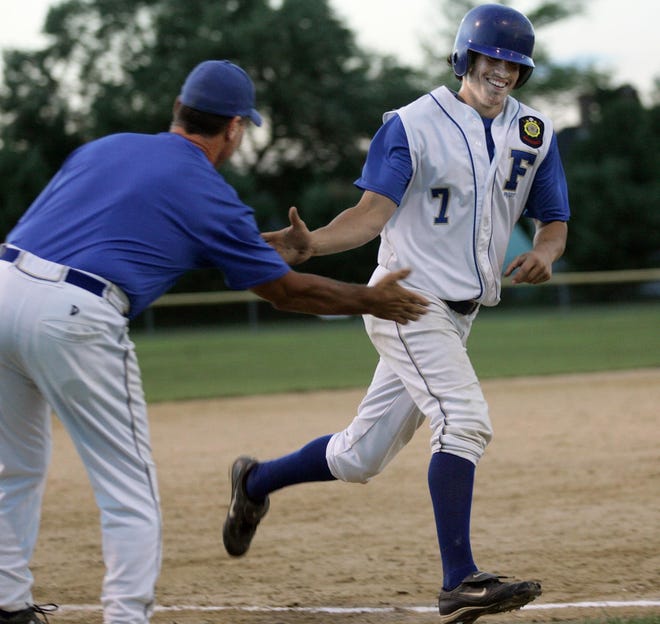 Framingham Legion's Jeff Tardiff gets congratulated from assistant coach Barry Bennett after hitting a three-run homer.