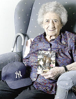 Fannie Vuolo of Middletown holds her Yankee hat and an invitation to her 100th birthday party.