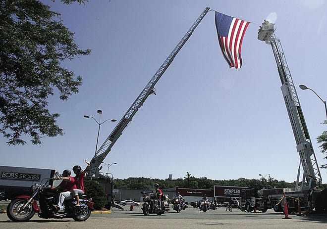 Bikers set out beneath an American flag hoisted up bythe Raynham Fire Department Sunday from the Staples shopping plaza onRoute 44 in Raynham to begin Brian’s Ride, a fund-raising motorcycle ride in memory of Brian Mello, 43, who was killed March 25 in an accident in Middleboro.