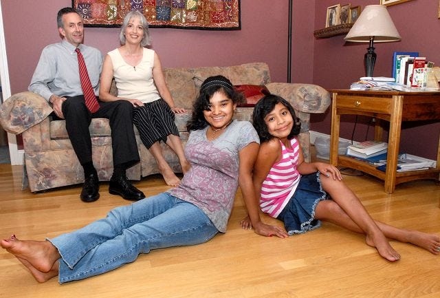 Beth Lorden/Democrat photo
Dennis and Aleka Munroe sit with their adopted daughters, Styliani, 13, of Costa Rica and newest family member Delmi, 9, from Guatemala, in their Portsmouth home.