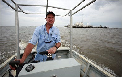 Oystermen like John Tesvich share offshore Louisiana with energy interests. At right, gas tanks.
