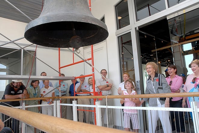 Catherine Chapman, 8, and Catherine Skinner, a 50-year veteran of Riverdale Mill, ring the bell from the Riverdale Mill that has been installed in the Carlos Dupre Moseley Building at the Chapman Cultural Center on Wednesday.
