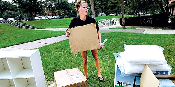 New University of Florida student, Shkun Scott, 18, background, and her mother, Cheryl, right, of Deltona, try to eliminate some items for her dorm room after finding out she has two roommates and less space than she thought when she packed.