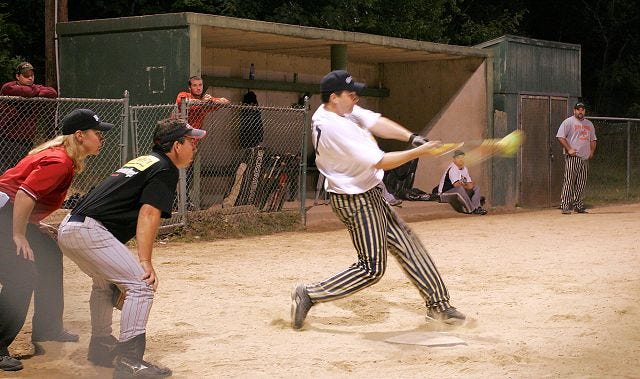 Aaron Leclerc/Staff photographer 
Enviro-Advantage's Scott Denis rips a hard hit to the outfield during Thursday night's Rochester Men's Softball League B Division Championship playoff game against Wild Willy's at Riverside Park. Enviro-Advantage captured the title, 18-6.