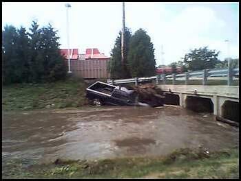 This morning's deluge carried away a pickup truck and wedged it partially under a bridge over Keith Creek behind McDonald's on Charles Street.