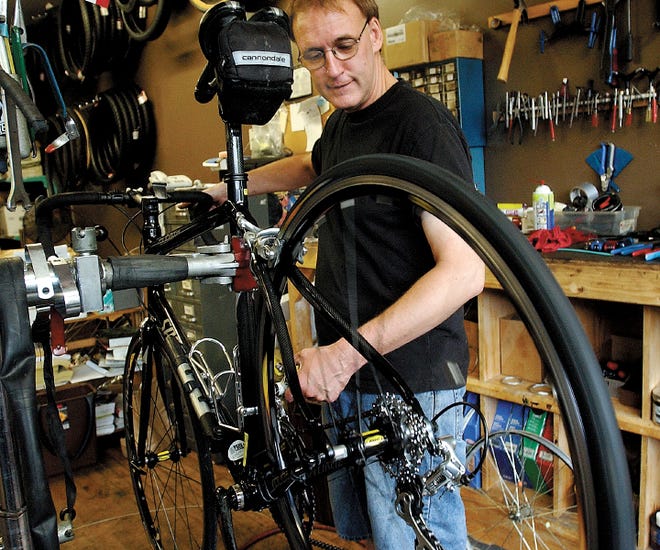 Al Merson works on a bike in his shop. The hours are long, but he doesn’t mind that too much.