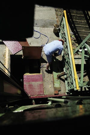 Larry Niebert cleans up a piece of frameworks from the Park Avenue bridge last Friday afternoon.