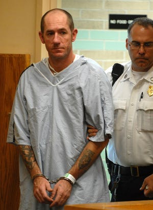 Cliff Fitzgerald of Framingham is led into Natick District Court for his arraignment yesterday.