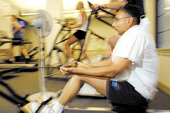 Baju Hari works out on a rowing machine at the Western & Southern Financial Group building, Aug. 16, 2007, in Cincinnati. The company is encouraging employees to work out to reduce their health risks as insurance rates climb. (