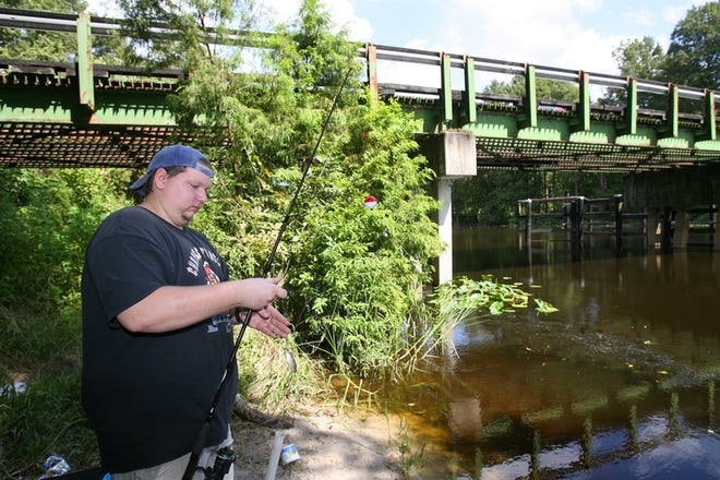 Joe Richards of Belleview baits his hook with a shiner while fishing on the Ocklawaha River near the Sharpes Ferry Bridge in Silver Springs. The Florida Department of Environmental Protection is developing a plan to restore the river's water quality.
