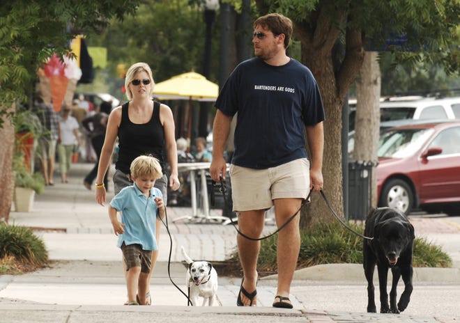 Molly and Christian Schaumann and son Sonny, 3, walk their dogs Khola (left) and Pigpen along Laurens Street in Aiken.