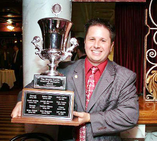 Jason Langdon — Stryker the Up-Close Magician — holds a trophy he won at the Strolling Olympics, a magic competition in California.