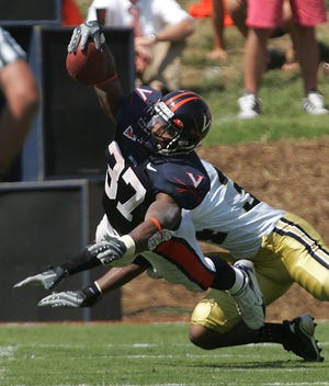 Virginia's Cedric Peerman reaches for a first down after getting past Georgia Tech defensive back Avery Roberson on Saturday.