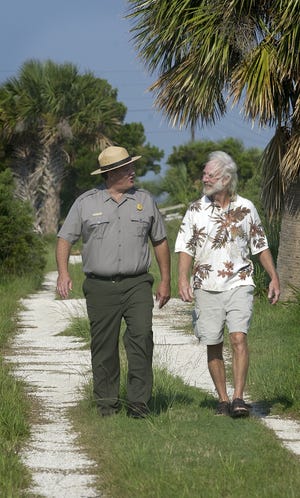 Charles E. Fenwick, left, superintendent of Fort Pulaski National Monument, walks with Paul Wolff, Tybee Island city councilman, on the completed portion of the McQueen's Island Rails to Trails. They hope to extend the trail to the Lazeratto Creek Bridge. Steve Bisson/Savannah Morning News