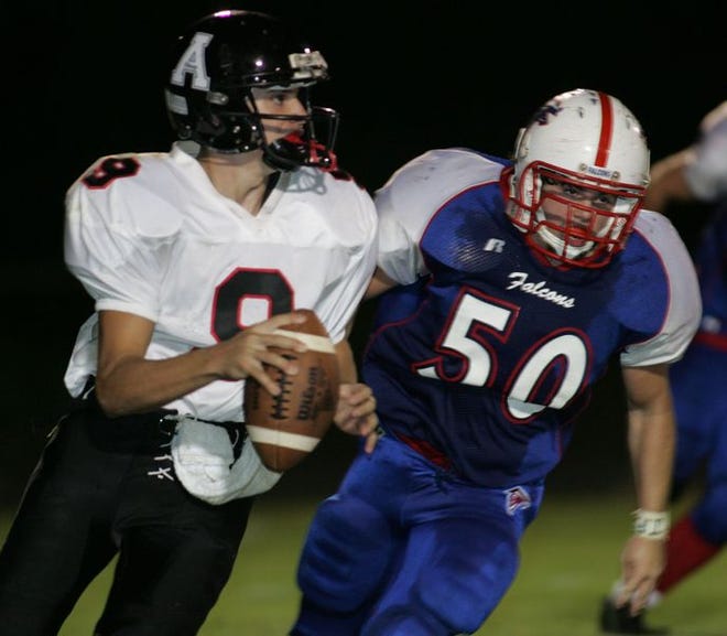 West Henderson's Tyler Moore tries to bring down Avery's quarterback Adam Pate.