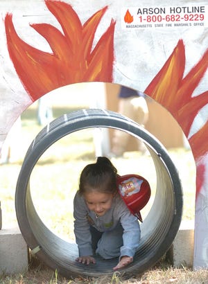 Kaitlin Loughlin, 5, of Ashland tries to escape from a "fire," during the fire station open house.