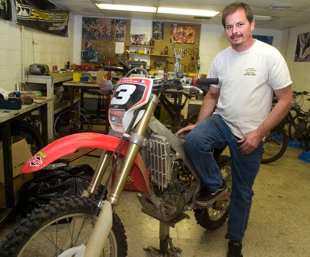 Motorcyclist Roger Hurd with the practice bike he used to prepare for the Baja 1000 in November. Two years ago, Hurd, a former professional racer, was diagnosed with Parkinson's disease, but has returned to racing despite the degenerative nerve disorder.