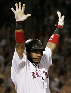 Manny Ramirez poses at home plate, arms raised, after blasting the Red Sox to a 2-0 ALDS series lead with a walk-off, three-run home run to beat the Angels.