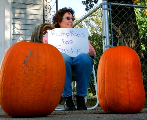 Peggy Teeters sells pumpkins Oct. 9 on Ridge Avenue near Bell Avenue in Rockford. Teeters started with 25 pumpkins and was down to 16 late in the afternoon. If she doesn't sell them, Teeters said, "I'll just give them away."