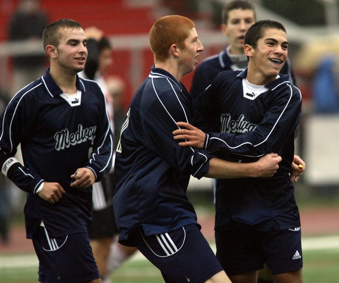 Medway's Sean Cullen (middle) and Peter Casinelli (right) celebrate their important boys soccer win at Holliston.
