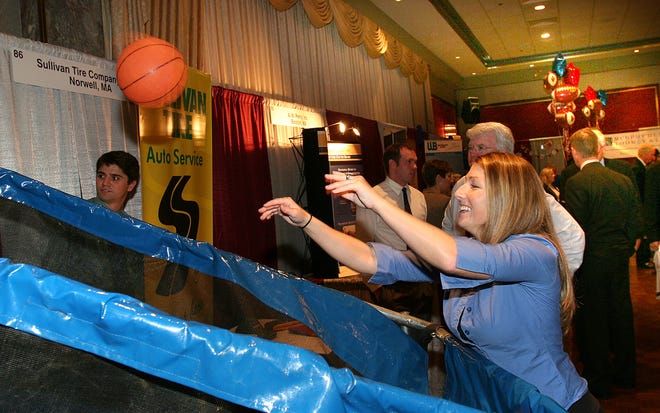 Jill Healy of Sullivan Tire tries to win a prize at the South Shore Chamber of Commerce Expo on Tuesday by sinking the most hoops in 20 seconds.
