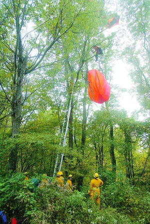 Paraglider Gary Ward of Rushville hangs from a tree on Italy Valley Road Thursday afternoon.