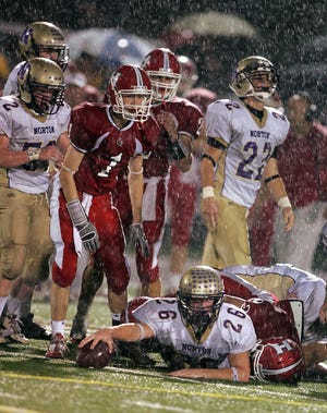 Norton's Mike Glassman get brought down as Holliston's Dave Brumber (1) looks on during Friday's game.