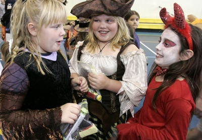 Tammie Sell (from left), Tiffany Kreutzer and Samantha Hendon argue who has the most candy at the Enchanted Halloween Carnival at the Rivers Edge Recreation Center in Belvidere Sunday, Oct. 21.