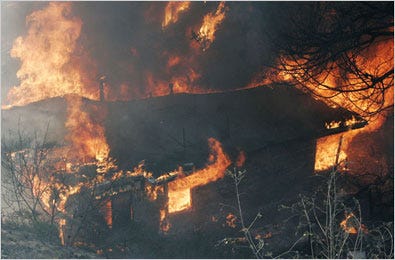 A structure burns below the Malibu Knolls in Malibu, Calif.