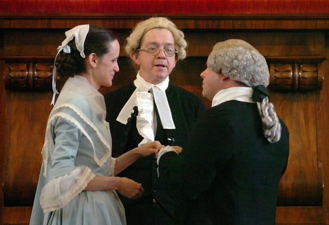 Abigail Elias, portraying Abigail Smith, holds out her left hand to accept a wedding ring from Michael LePage, right, playing John Adams. They stand before Henry Cooke, playing the Rev. William Smith, who officiated at the marriage ceremony.