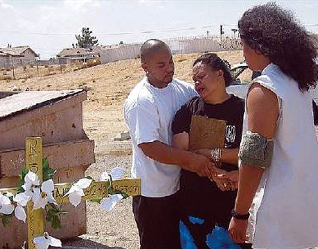 In this 2008 Daily Press file photo, Tua Penusatele, center, is comforted by her sons Andrew, left, and Benjamin, right, as she holds a picture of her mother, 'Sue' Tausili, who was murdered in 2007. Tausili was fatally shot and her grandson wounded after he confronted taggers outside their home.