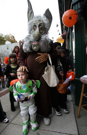 “Troll” Leon Roberge keeps a protective (but creepy) hand on his son, Christopher, who’s dressed as Buzz Lightyear, at Marlborough’s downtown trick-or-treat and Horribles Parade last Friday evening.
