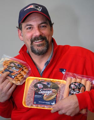 Andy Zupan of Game Day Foods holds packages of Patriots Gridiron Grillers.