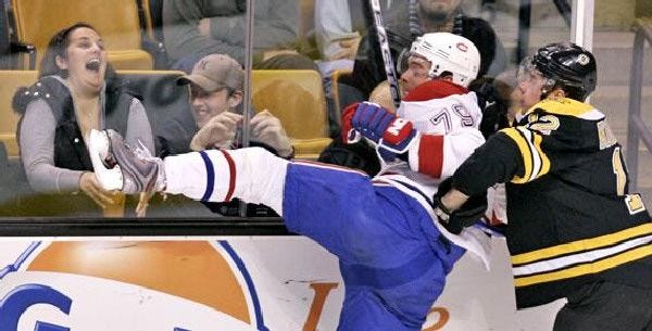 A Boston fan takes pleasure in the Bruins’ Chuck Kobasew, right, hitting Montreal’s Andrei Markov Thursday night.