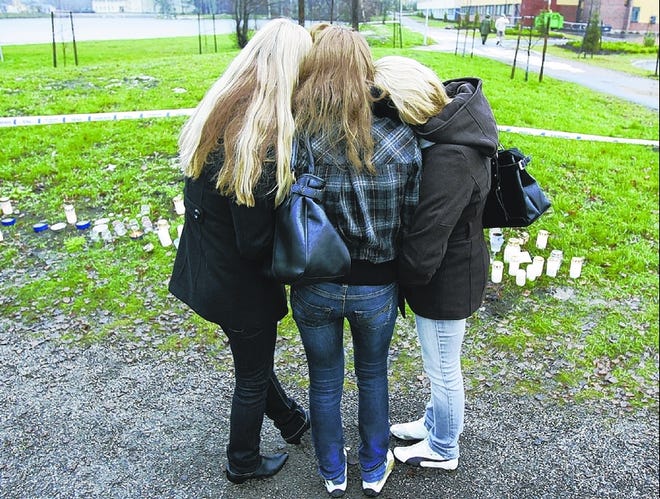Students mourn Thursday outside the Tuusula, Finland, high school where a suicidal gunman unleashed a deadly rampage.