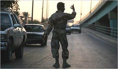 An Iraqi solder directs traffic near an exit ramp where a taxi driver was fatally shot on Saturday by a convoy guard in Baghdad.