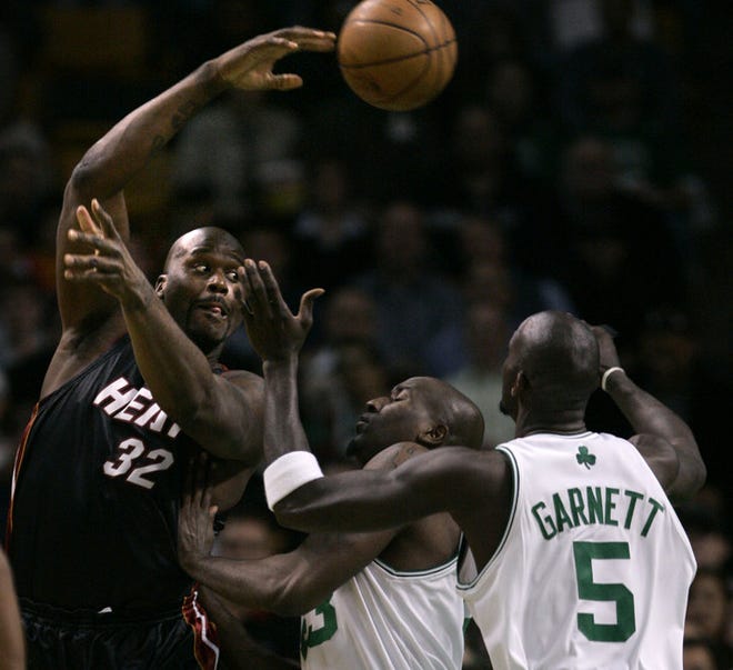 Miami's Shaquille O'Neal dumps off the ball as he is pressured by Kevin Garnett.