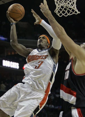 Charlotte's Gerald Wallace drives to the basket for some of his 27 points despite the defense of Portland's Joel Przybilla