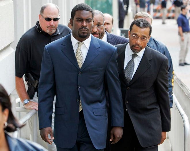 Atlanta Falcons quarterback Michael Vick arrives with his attorney Billy Martin, right, at federal court in Richmond, Va., in this August file photo. Vick surrendered to U.S. marshals Monday, three weeks before his sentencing on a dogfighting charge.