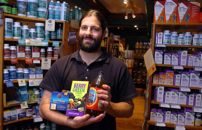 Common Sense Wholesome Food Market in Plymouth's manager Bryan Hebert shows a variety of the store's supplements. Hebert encourages whole-food solutions to dietary concerns.