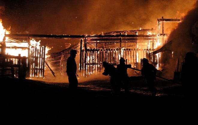 Firefighters are silhouetted by a raging fire destroying a horse barn in front of them Tuesday, November 27, 2007, at 9329 Kennedy Road in Marcy. Several horses were rescued from the burning building but it is not clear if all of them are safe. Maynard and Deerfield Fire Departments responded to the blaze.