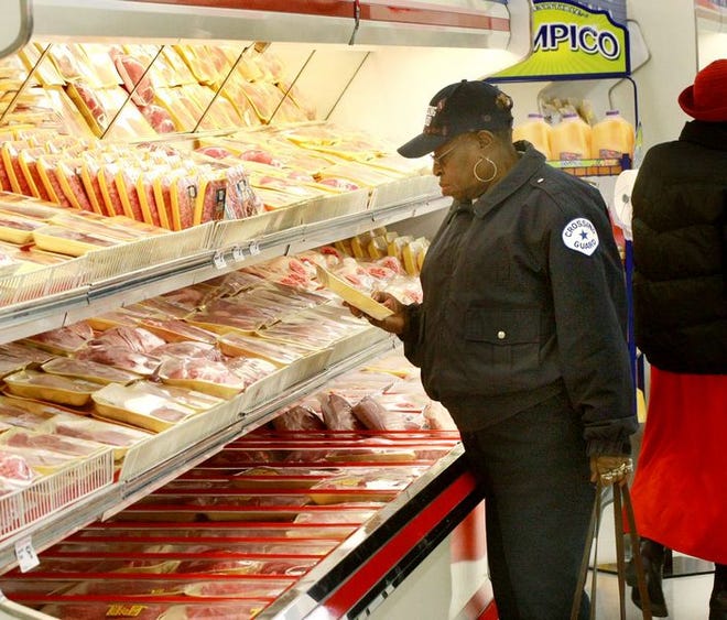 Elouise Moss, below, a crossing guard at Mary H. Wright Elementary School, was the first customer of the new Save-A-Lot, above, that opened Wednesday on South Church Street in Spartanburg. "This means the world to me," Moss said of the convenient location.