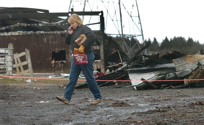 Michele Kreimeyer, co-owner the Burgundy Hill horse stable, walks past the charred remains of the family-run horse boarding business on Kennedy Road in Marcy, Wednesday, November 28, 2007, after a fire ravaged it late Tuesday night. The fire killed 25 horses, while eleven survived and two remain in serious condition. Fire officials said they probably will never know what caused the blaze.