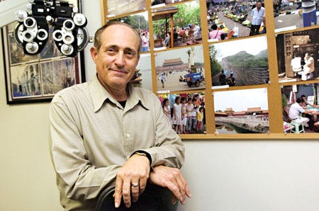 Dr. Gene Zanetti, an Ocala optometrist, says the travel photographs on the walls of his exam rooms have helped him forge bonds with his patients. He’s shown in front of pictures he shot during a recent trip to China.