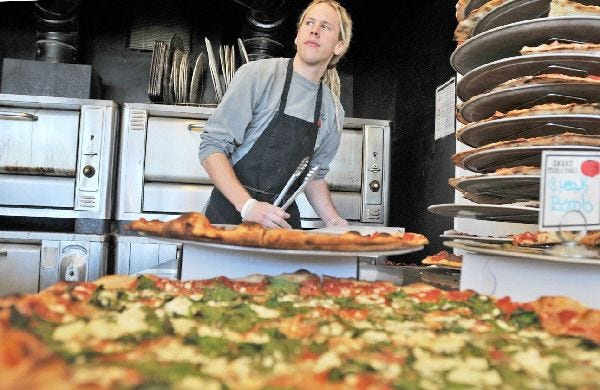 Canadian Sean Aiken, 26, works at Sweet Tomatoes Pizza in Osterville. Aiken is working his way around the country one week at a time to raise money for charities, and he's posting the story on his Web site.
