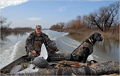 Bob Wafel, of Appleton, Mo., and his dog Gunner boat back from the the duck blind just as the sky begins to clear following a rainy, yet successful morning of hunting.