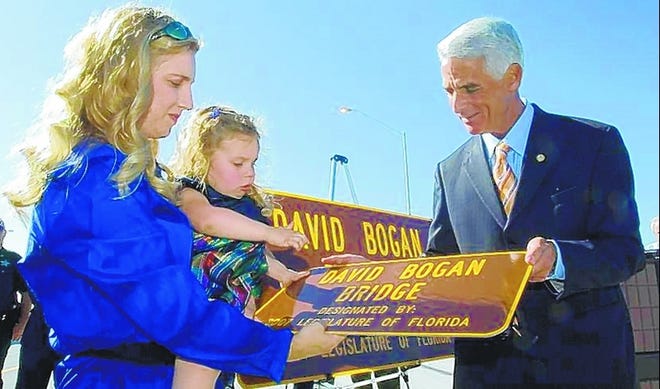 Dove Bogan and her daughter Joy are given a replica road marker bearing her husband's name by Gov. Charlie Crist after he dedicated an Interstate 10 bridge for her late husband, David Bogan, an FDOT project manager, on Wednesday.