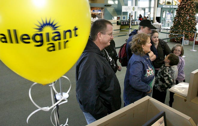 Fran Guillame (left) and his family check in Friday, Dec. 14, for Allegiant Air's first flight from Rockford to Fort Lauderdale, Fla., at Chicago-Rockford International Airport.