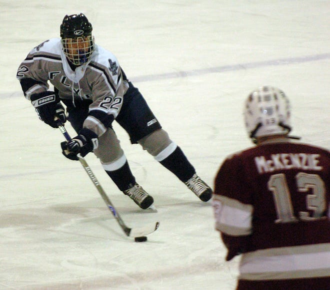 Framingham's Tommy Manna tries to skate past Arlington's Kevin McKenzie during the Flyers' 2-1 win.